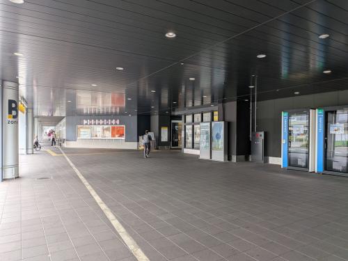 高架下の屋根付き通路に、店舗と個室型ワークブースが並んでいる様子
