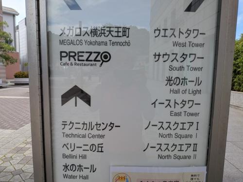 スポーツクラブとカフェ＆レストランの表示、下部に「無料で誰でも」と読める催しの貼り紙がある横浜ビジネスパークの案内板