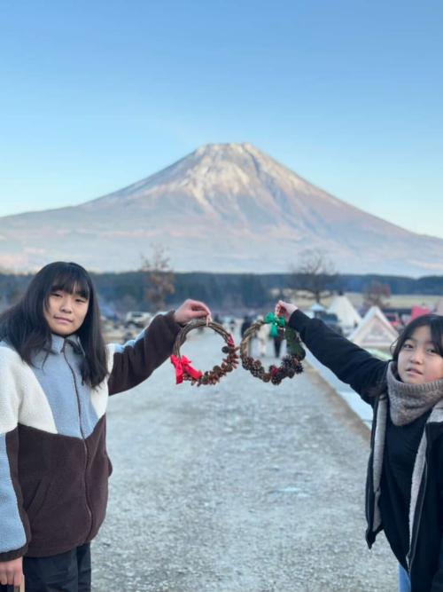 富士山を背景に、子どもが手作りのリースを持って記念撮影