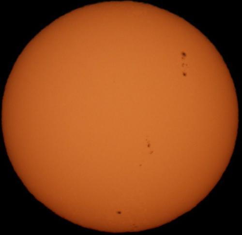 太陽の写真です。表面に、黒点と呼ばれる暗い点がいくつか見えます。