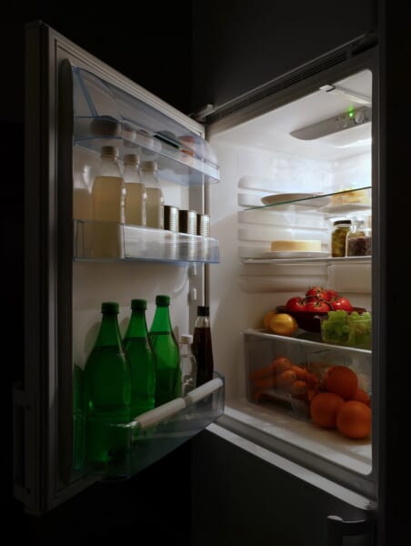 夜に扉を開けた家庭用の冷蔵庫で、食べ物や飲み物が入っています。