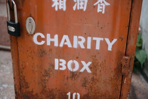 「CHARITY BOX」と書かれた、鍵のかかったさびた募金箱です。