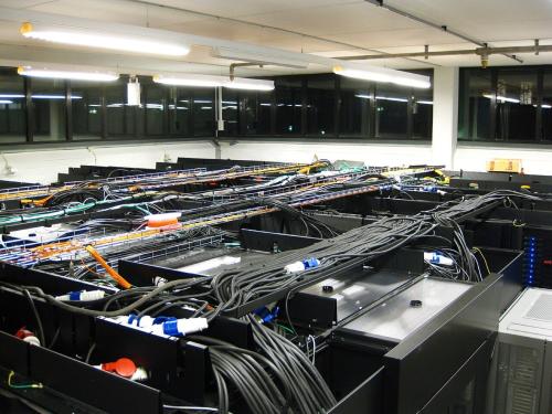 王立工科大学の並列計算機センターにあるサーバー室です。太い黒のケーブルは電源、オレンジと黄色は光ファイバー、緑と灰色はLANのケーブルです。