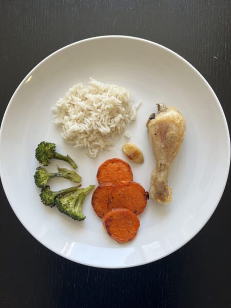 鶏肉とごはん、ブロッコリー、サツマイモを白い器に盛った、手作りの低脂肪の食事です。