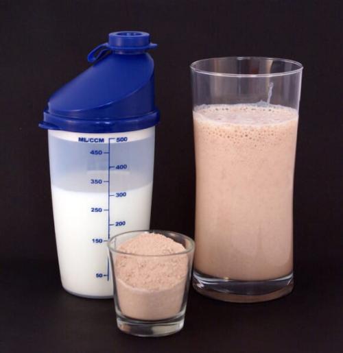 チョコレート味のたんぱく質の粉(中央)約25gと牛乳(左)300mLで作った、栄養補助のミルクシェイク(右)です。