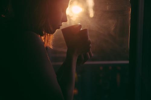 カップの飲み物に口をつける女性です。研究の参加者のうち、とても熱いのが好きな人はおよそ7人に1人でした。