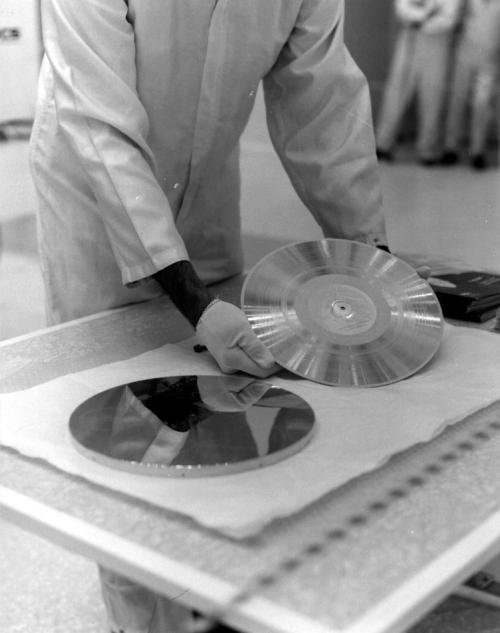 1977年、ボイジャー1号に取り付ける前の金色のレコードを準備しているところです。このレコードがどこかの星の近くにたどり着く日は、まだはるか先です。