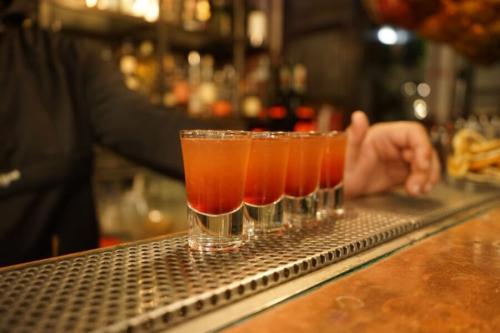 バーのカウンターに並んだ、小さなグラスのお酒です。