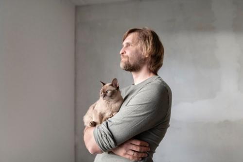 男性に抱かれる猫
