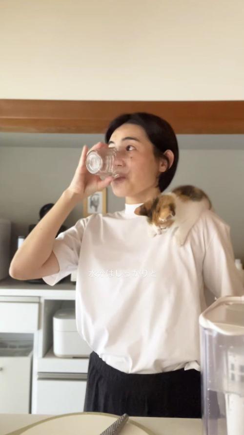 コップに入った水を飲む女性