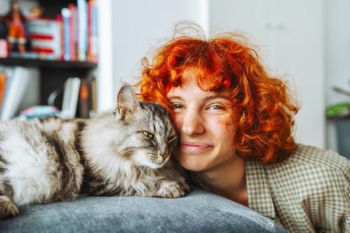 顔を寄せ合う女性と猫