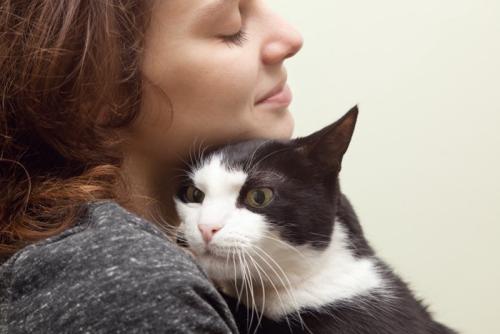 顔をくっつけ合う女性と猫