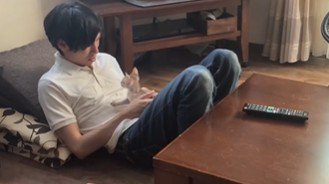 男性のおなかの上で見つめる猫