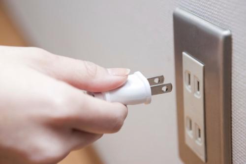 プラグを持った手とコンセント