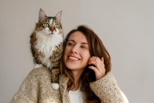 笑顔の女性の肩に乗る猫