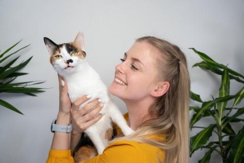 女性のからだに手を突っ張る猫