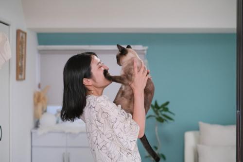 女性の顔に手をかける猫