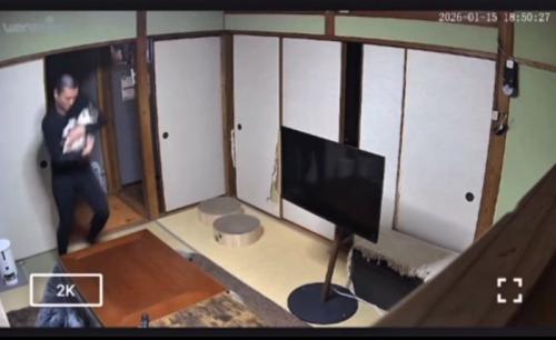 猫を抱っこしてステップを踏む男性
