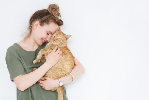 猫を抱いてほおずりする女性