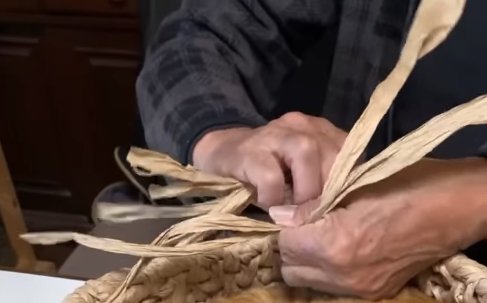 紙紐を編んでいる飼い主の手元アップ