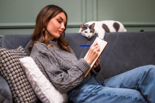 ノートを見る女性と猫