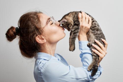 猫を抱き上げる女子学生