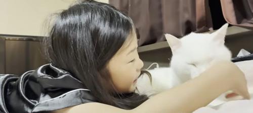 ベッドの上に寝転ぶ子どもと猫