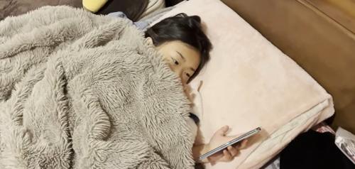 ベッドに寝ている子どもと猫