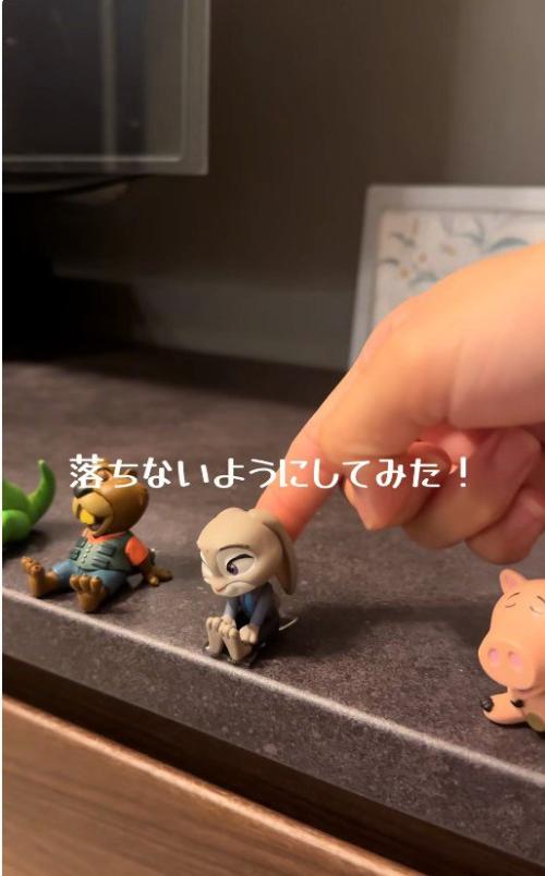 テレビ台の上に並んでいるフィギュアつついている人