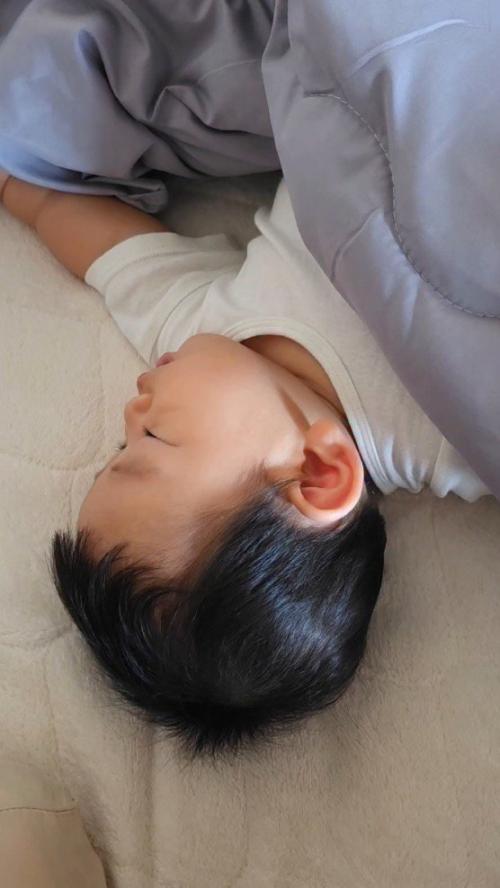 布団の中で眠る赤ちゃん