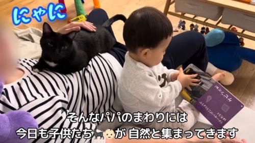 猫を抱いて子供の世話をする人