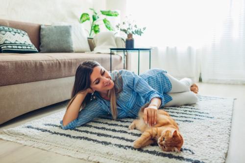 ラグの上で寝転ぶ女性と猫