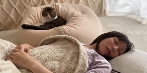 眠る飼い主と丸くなる猫