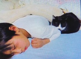 横になった男の子の背中に寄り添うきいちゃん