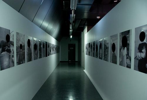 通路の両脇にズラリと並ぶ「黒塗りの写真」