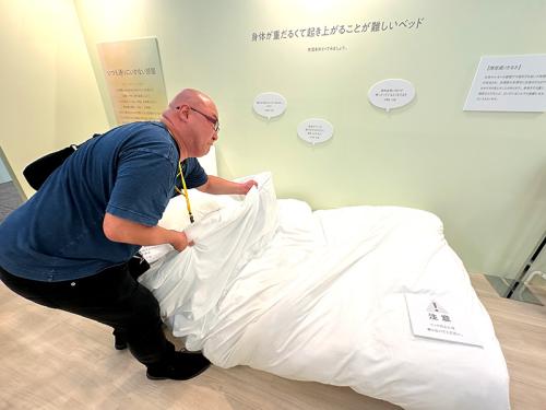 重りのついた掛け布団で、生理による身体の重さを表す展示