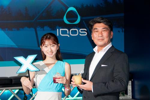 ラウンジで提供されるドリンクを持つコンパニオンと、フィリップ モリス ジャパンの高橋さん