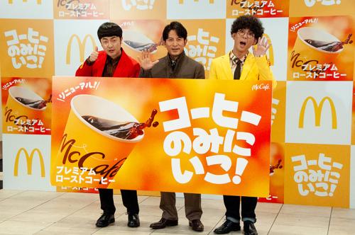 新しくなった「プレミアムローストコーヒー」（ホット）のボードを持つたくろう、岡田准一