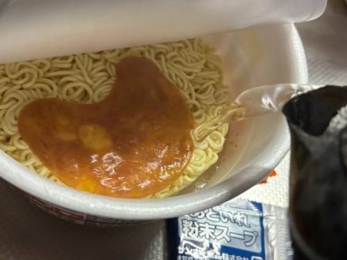 めんの上に焼豚をあけ、熱湯をカップの内側の線まで注ぐ