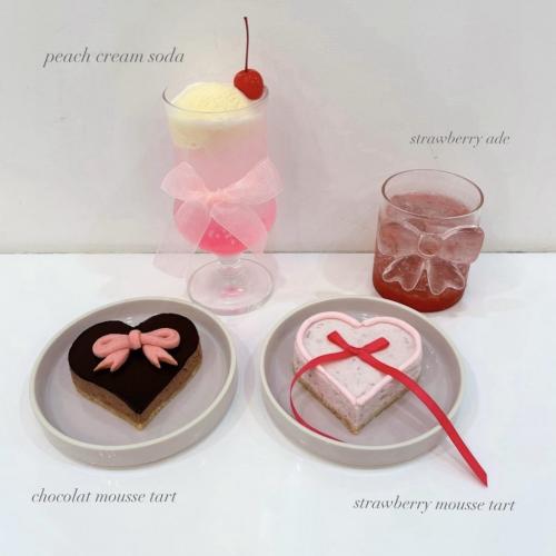 Cafe Ksyn'n(カフェ・カシノン)の人気メニューである、リボンが載ったハート型のチョコレートムースタルトとストロベリームースタルト、ピーチクリームソーダ、ストロベリーエイド