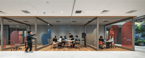 スタッフが大きな可動式の大型移動壁を動かしているオフィスの展示エリア
