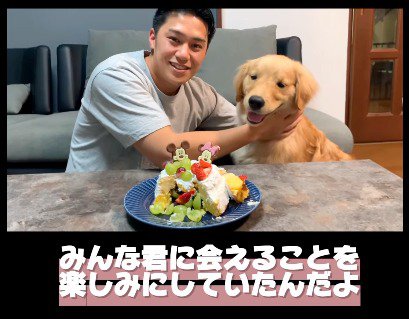 ケーキの前で写真をとる犬と男性