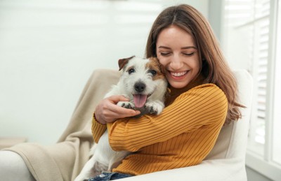 犬と顔を合わせる女性