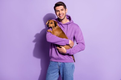 犬を抱っこする男性