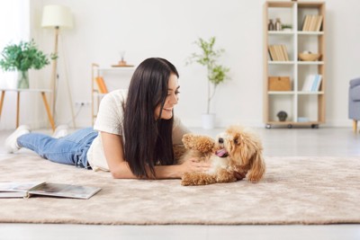 リビングで戯れる犬と女性