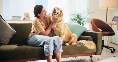 笑顔で女性の隣に座る大型犬