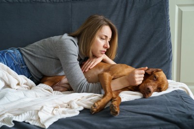体調が悪そうな犬を心配する女性