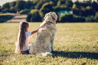 並んで座る犬と少女
