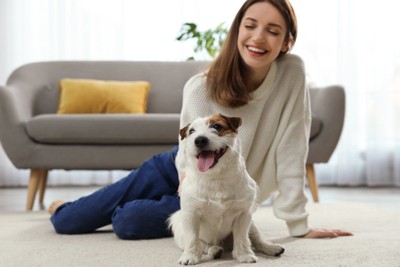 床に座る犬と女性