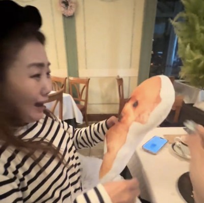 クッションを見て驚く女性